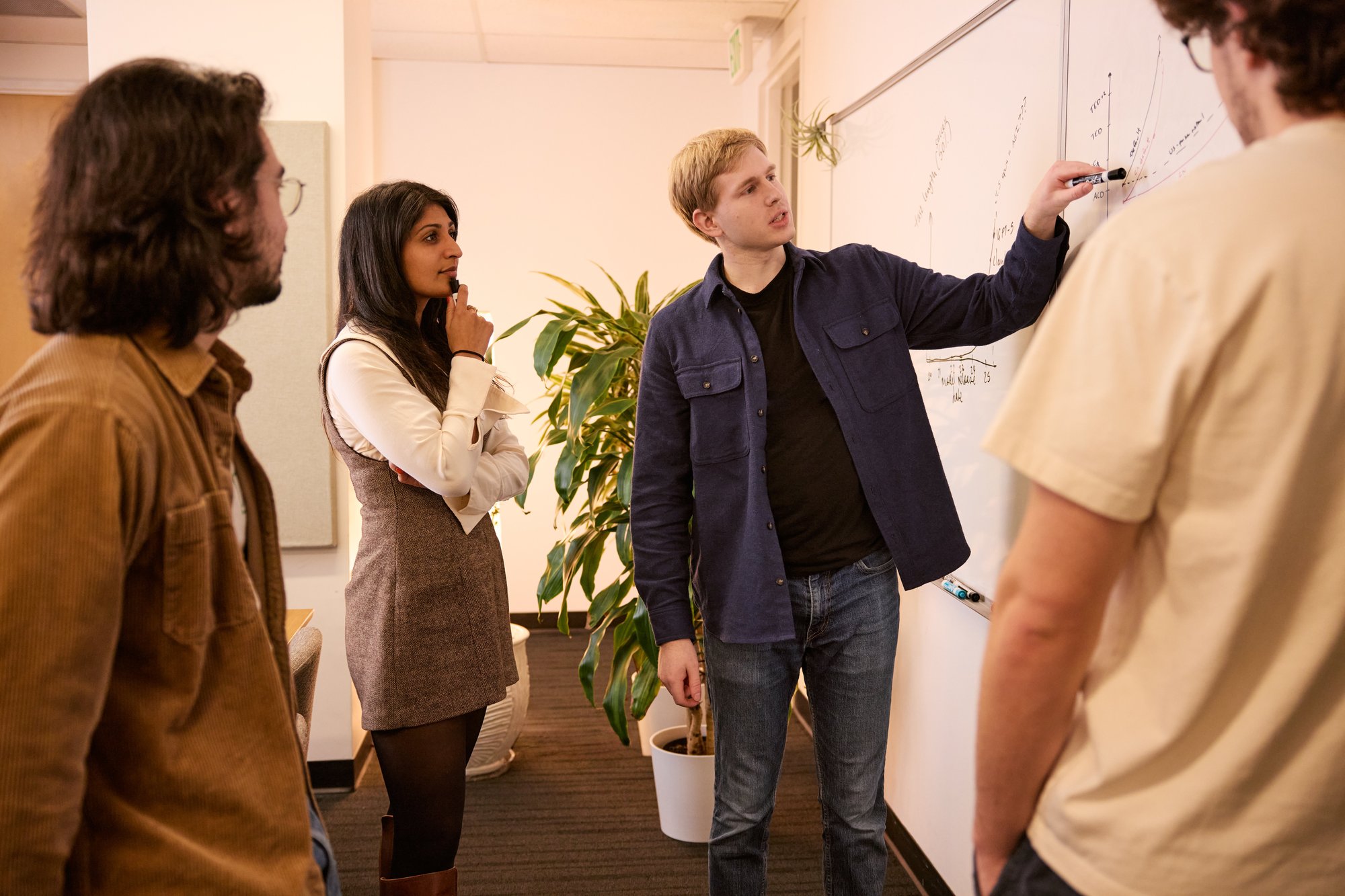 Four people collaborating on a whiteboard.