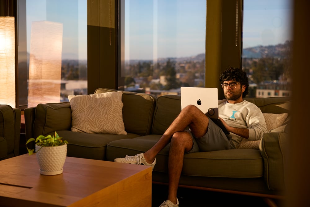 One person working on a couch with their laptop.
