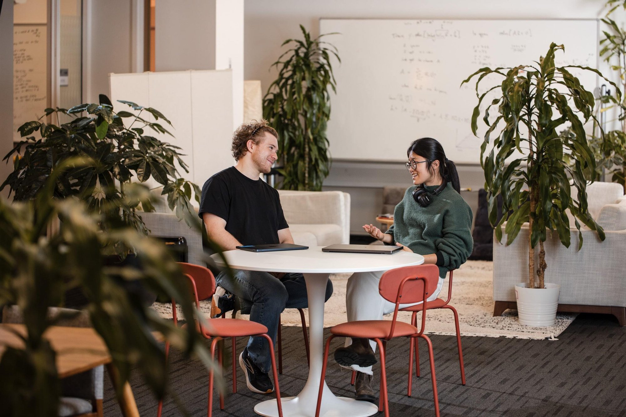 Two researchers deep in discussion while sitting at a table.
